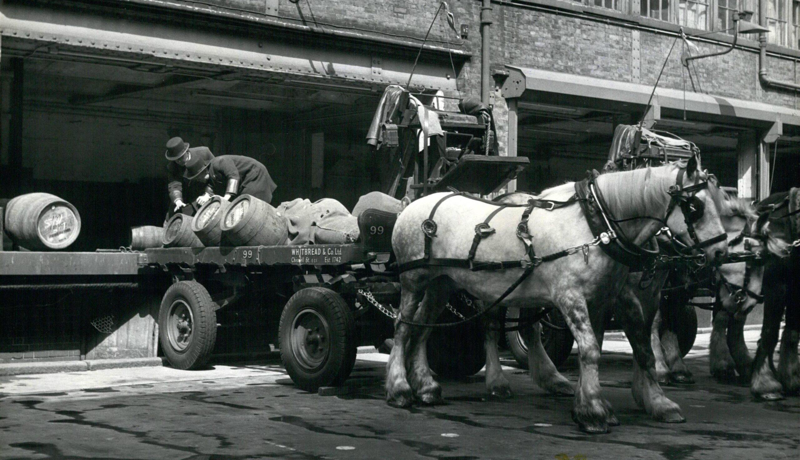 Drays are loaded outside Whitbread’s Chiswell Street brewery in the City in 1912 …